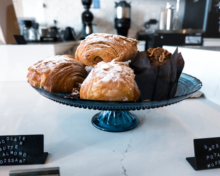 A variety of pastries on a display tray including Chocolate Butter Almond Croissants and a Sweet Potato Muffin. Naysayer features pastries from home bakers and small local bakers in Napa.