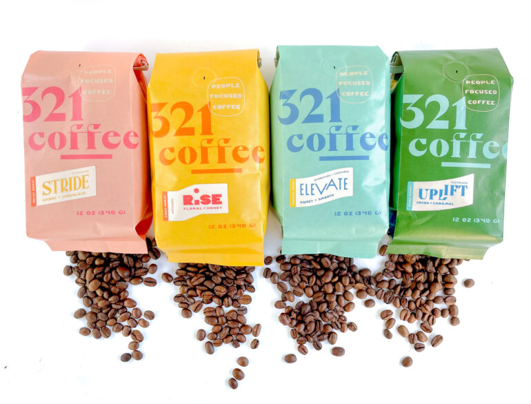 Four bags of 321 coffee in different colors on a white background with coffee beans spilling out beneath them